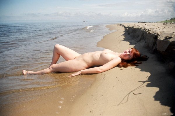 Обнаженная рыжая девушка на песке